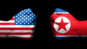 Flags of USA and North Korea  painted on two clenched fists facing each other on black background/ Tension between USA and North Korea  concept