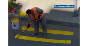 Мъж, облечен със сигнална жилетка, извадил кофа с боя и започнал да рисува жълта пътека на ръка. Снимка: СТОПКАДЪР BTV